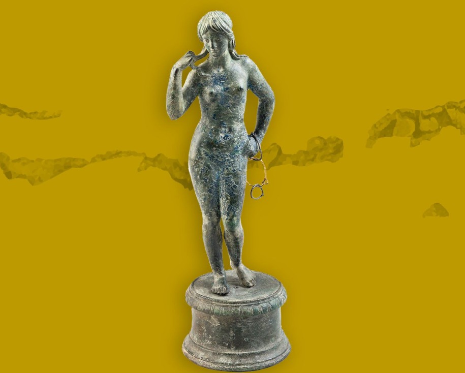 Cette statuette avait été déposée dans un sarcophage, elle porte autour de son bras trois anneaux, dont un en or, sans doute lié à un vœu.