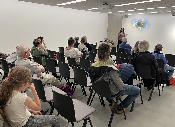 Photo d'une visite guidée de l'exposition "Bronze, l'âge retrouvé" par une médiatrice du Musée Savoisien. La médiatrice montre l'épée de Champagneux.