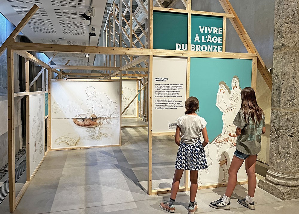 Vue de l'exposition "Bronze, l'âge retrouvé" au Musée Savoisien avec deux adolescentes en visite.