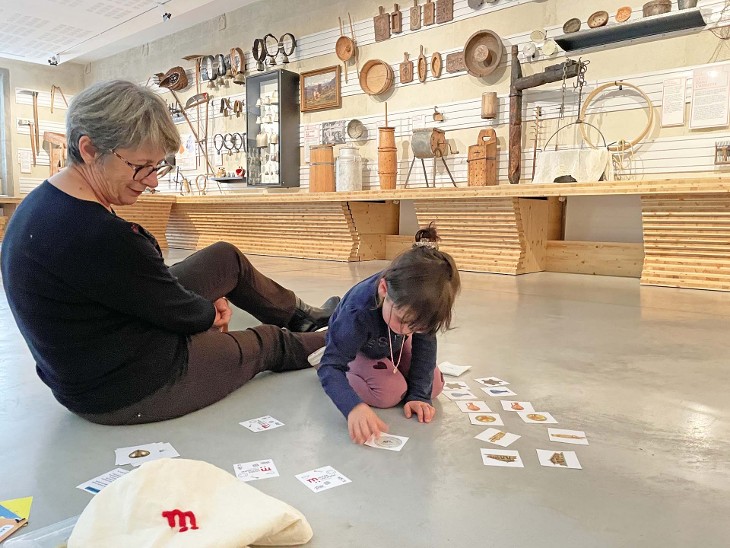 Photo d'une grand-mère et de sa petite-fille jouant au memory dans une salle du Musée Savoisien